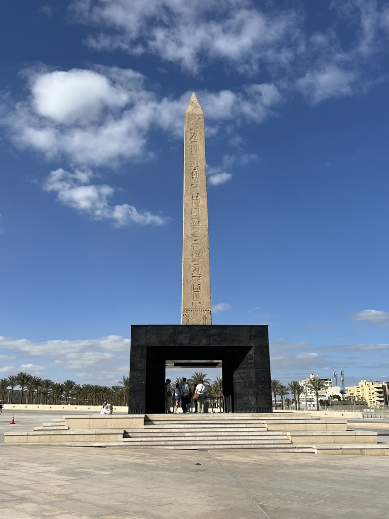The grand plaza serves as the threshold to the museum, where the towering 3,000-year-old granite needle meets the sleek, angular lines of 21st-century design.