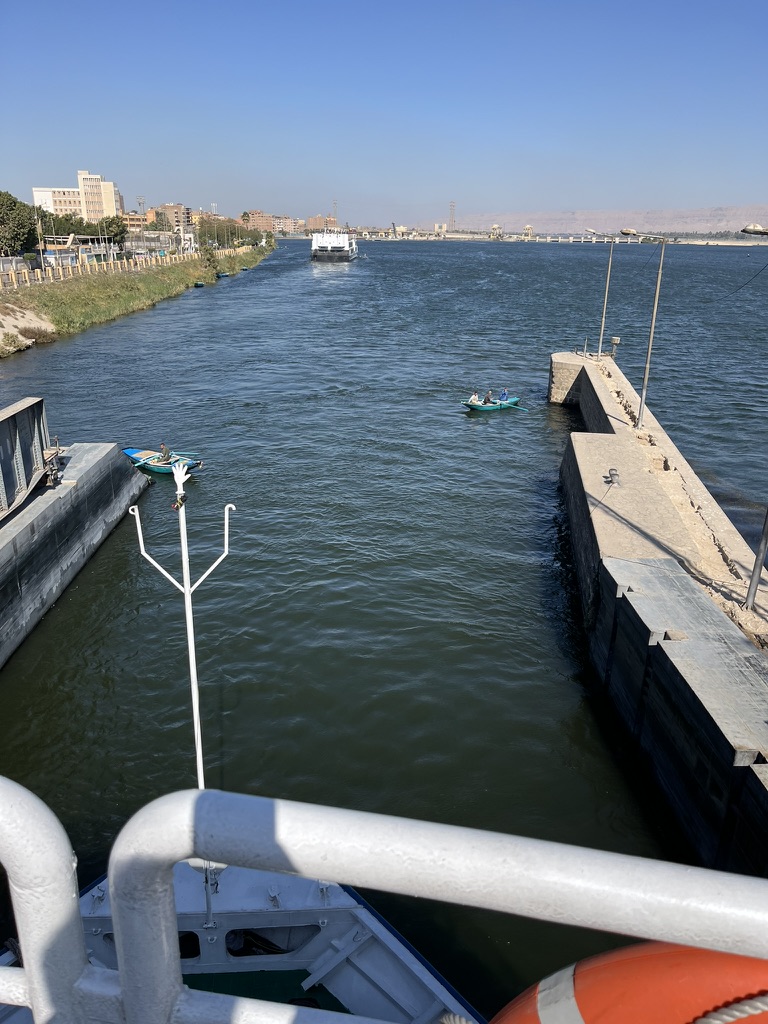 A Nile cruise ship positioned inside the concrete chamber of the Esna Lock, waiting for the water levels to equalize to continue its journey south.