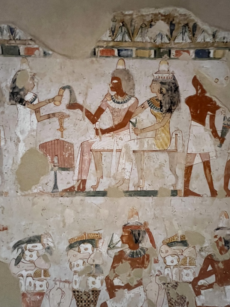 Noble's Tomb - A vibrant mural depicting a nobleman and his wife receiving offerings. They wear scented wax cones and hold lotus flowers, symbolizing rebirth and eternal life.