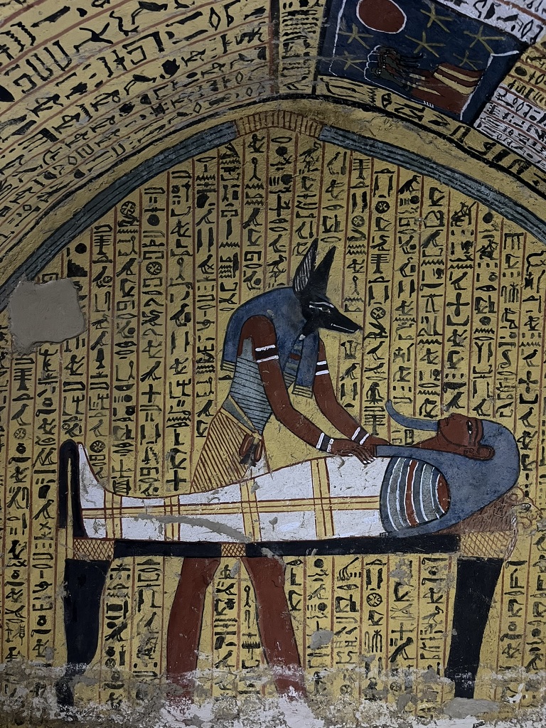 The iconic wall painting from the Tomb of Sennedjem (TT1), showing the god Anubis embalming the deceased on a lion-shaped funerary couch.