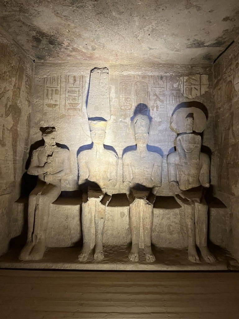 A detailed shot of the central niche above the entrance, featuring a statue of the falcon-headed sun god, Ra-Horakhty, flanked by reliefs of the Pharaoh offering Maat (truth/balance).