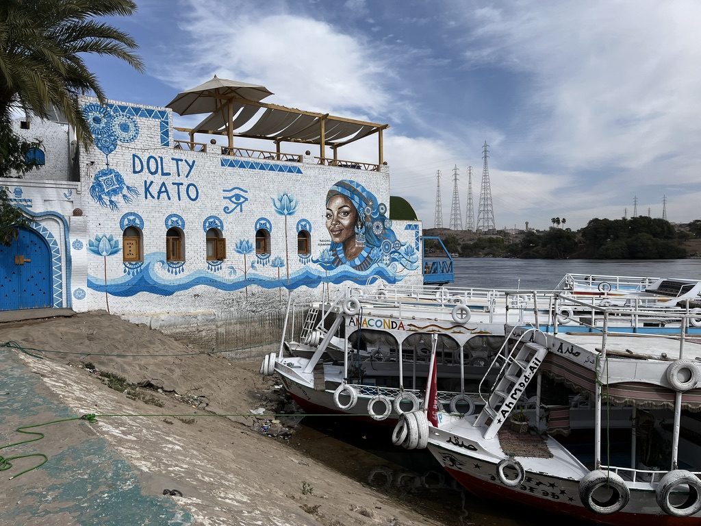 A vibrant, hand-painted Nubian guesthouse, featuring the geometric patterns and domed mud-brick architecture characteristic of the region.