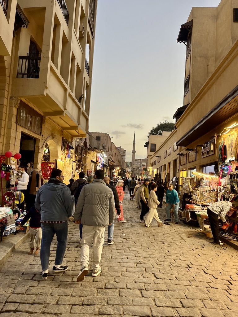 The bustling street leading to the monumental Bab al-Futuh (Gate of Conquests), one of the three remaining fortified gates in the Old City walls of Cairo.