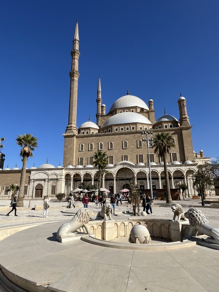 The imposing exterior of the Mosque of Muhammad Ali, showcasing its twin 82-meter pencil-shaped minarets and cascading domes built in the Ottoman architectural style.