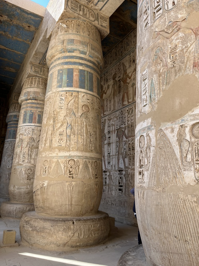 A close-up of the exceptionally deep-carved hieroglyphics and royal cartouches of Ramesses III on the sandstone pillars.