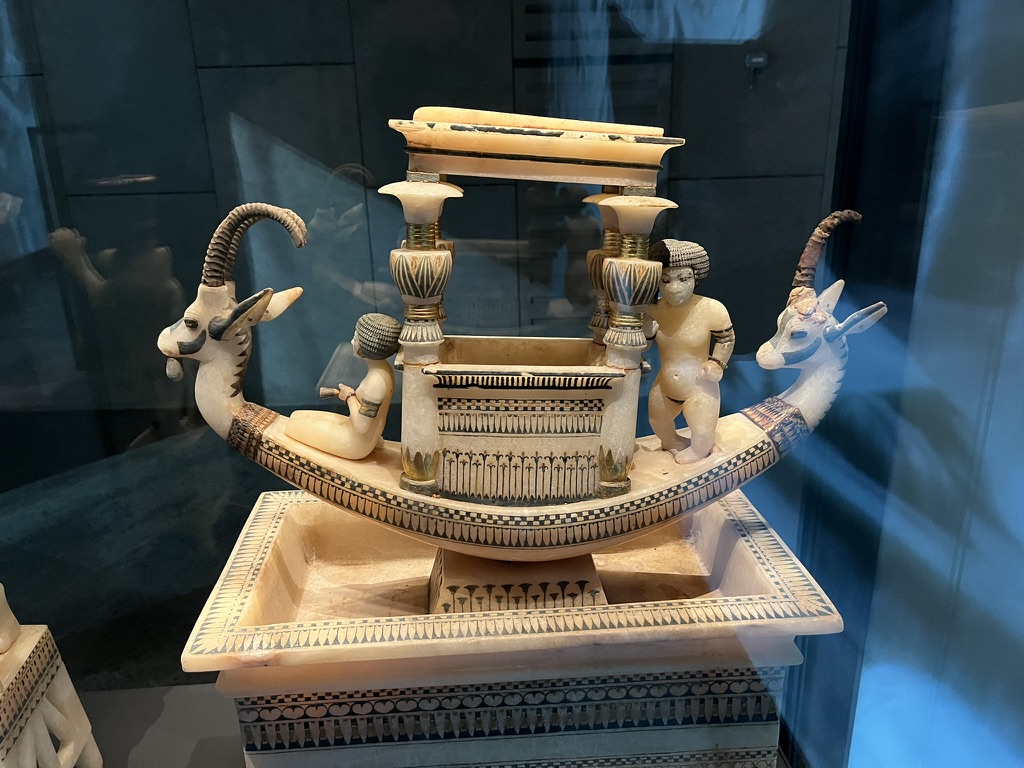 A ceremonial center-piece boat carved from translucent calcite (Egyptian alabaster), featuring the head of an ibex with real ibex horns and a tongue made of stained ivory.