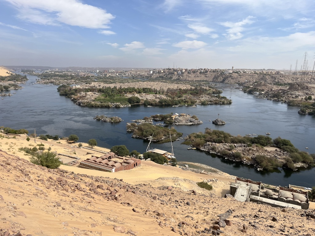A scenic perspective of the Nile River and the West Bank desert hills, taken from the colorful heights of a Nubian village.