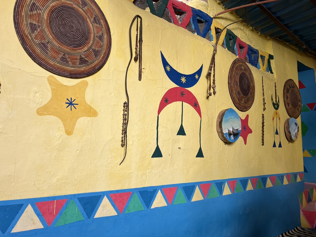 The interior of a Nubian residence where visitors are served traditional tea alongside small Nile crocodiles kept in domestic enclosures.