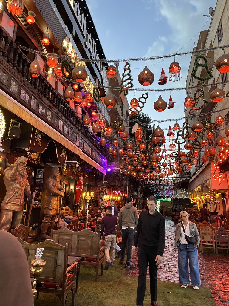 Rows of glowing, handcrafted brass and copper lanterns, known as fanous, illuminating a shopfront in the heart of the 14th-century bazaar.