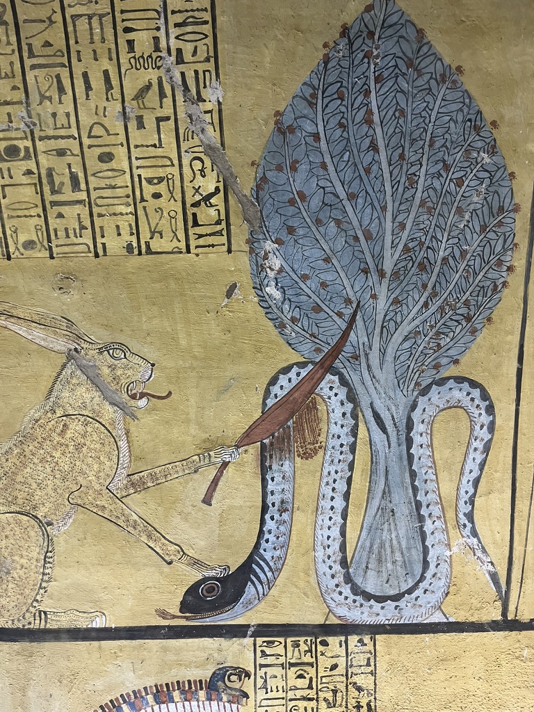 A vivid wall painting depicting the "Great Cat of Heliopolis," a manifestation of the sun god Ra, decapitating the chaos-serpent Apep beneath a sacred persea tree.