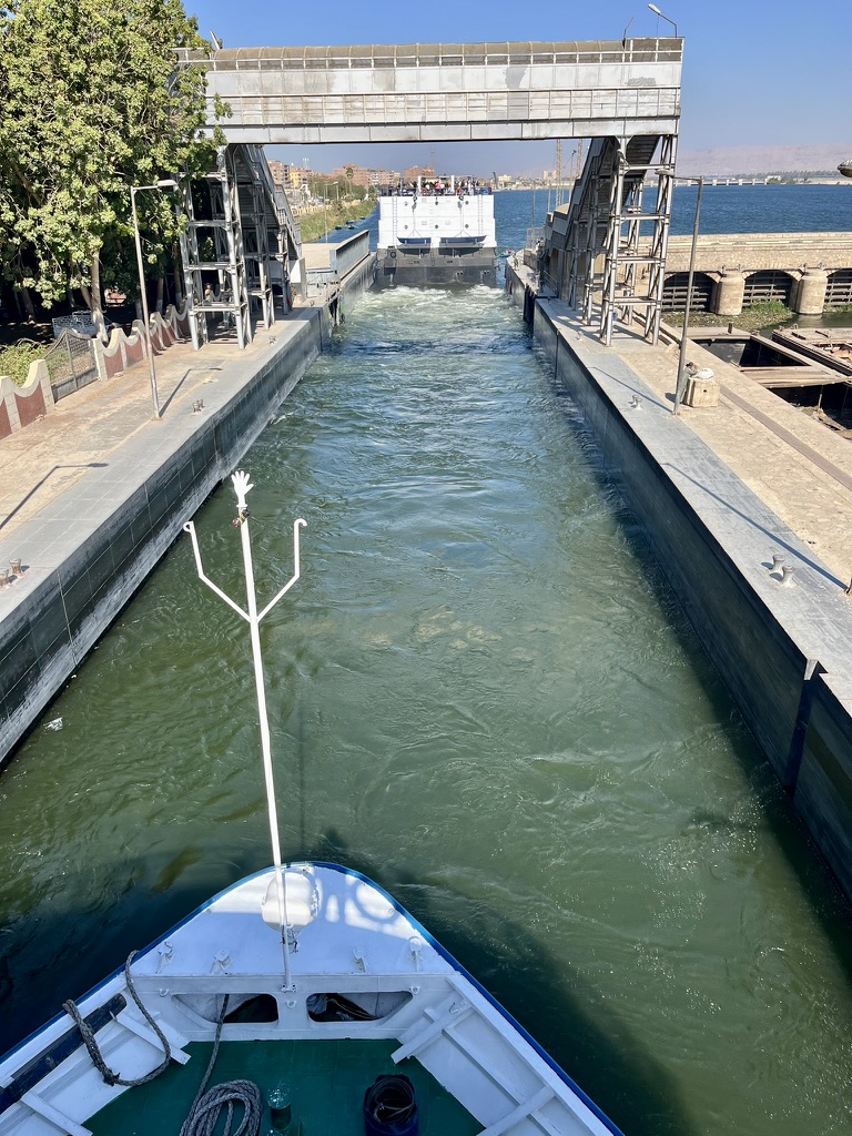 Massive cruise ship squeeze into the narrow stone walls of the Esna Lock.