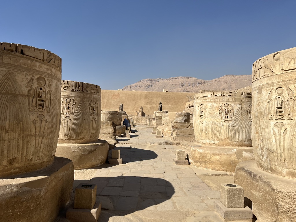 A detailed wall relief in the second court depicting Ramesses III presenting ornate incense burners and libations to a row of seated deities, including Thoth and Hathor.