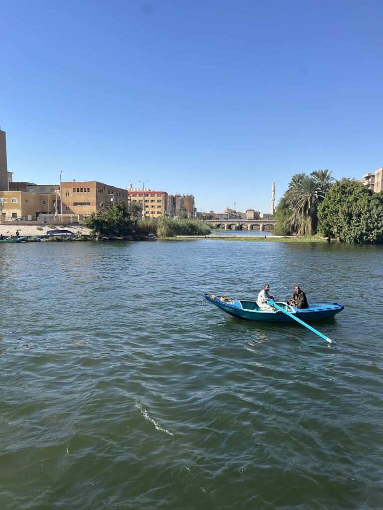 Local fishermen navigate the Nile currents in their vibrant blue boats