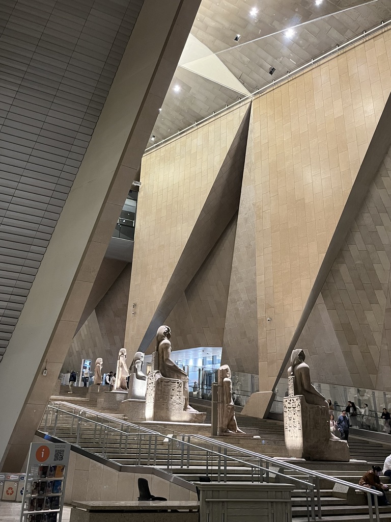 Looking up the 108 steps of the Grand Staircase, where more than 60 colossal statues, columns, and sarcophagi are arranged chronologically to tell the story of eternal kingship.