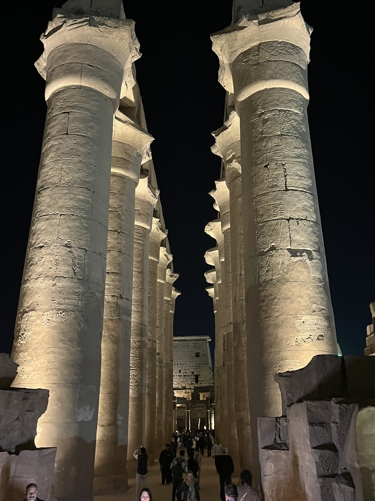 A view through the illuminated processional colonnade, featuring 14 massive papyrus-capital columns that reach a height of 16 meters.
