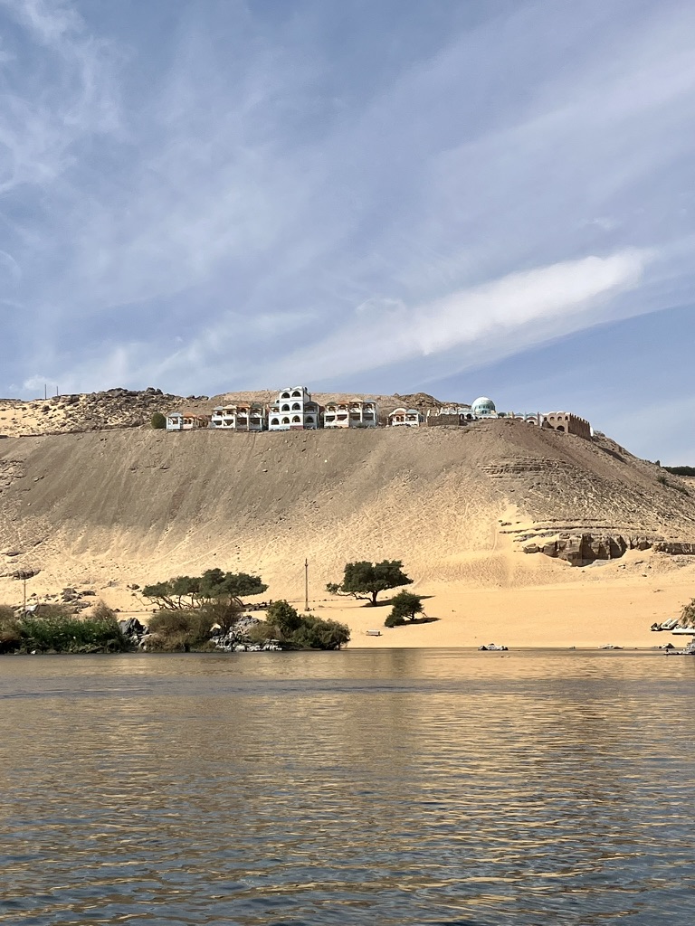 A sandy swimming beach on the West Bank of the Nile, with views of the southern tip of Elephantine Island.