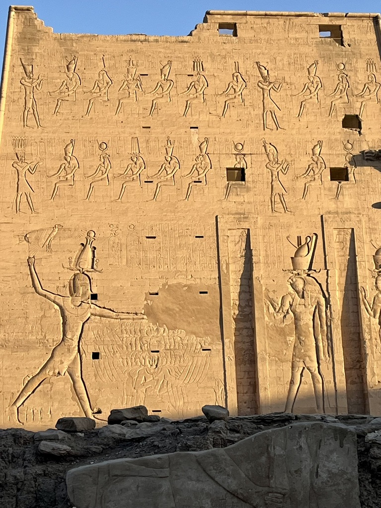 Detailed hieroglyphic reliefs on the exterior sandstone wall of the Temple of Horus at Edfu.
