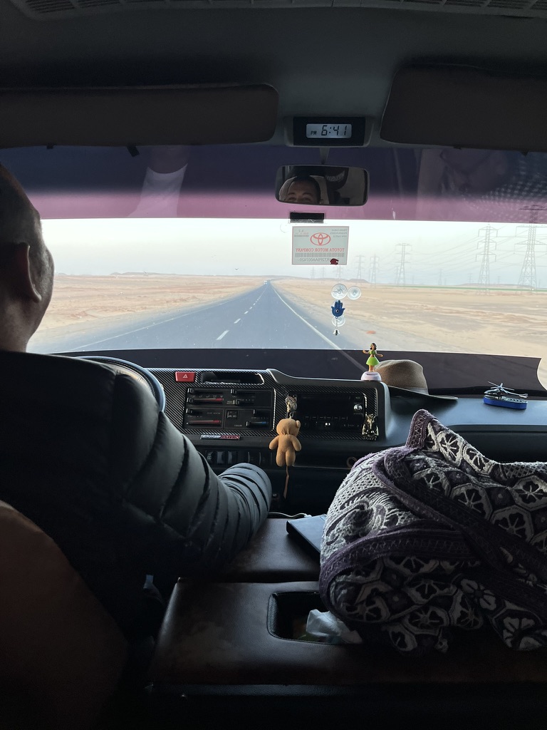 The long, straight expanse of the Abu Simbel highway cutting through the Sahara Desert during the early morning hours.